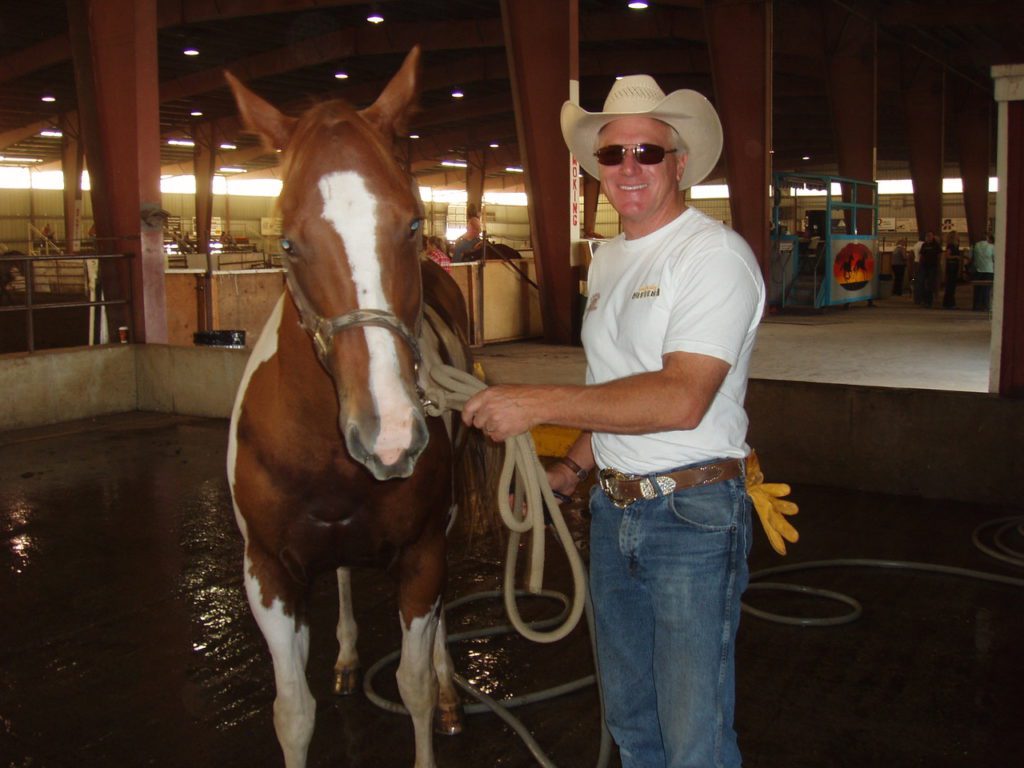 Image of Steve Spratt in jeans and cowboy hat with paint horse Sweets at home